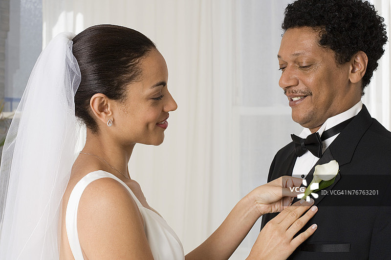 新娘将鲜花别在父亲的翻领上图片素材