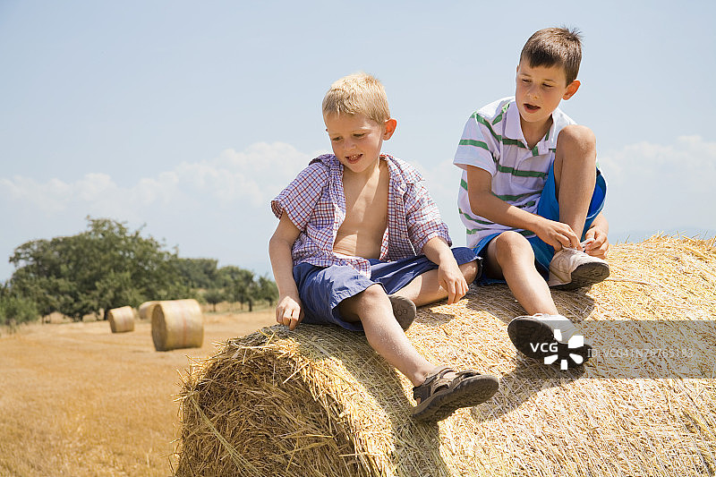 坐在干草堆上的男孩们图片素材