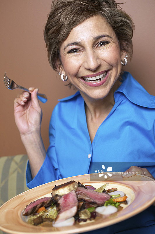 女人端着一盘美食图片素材