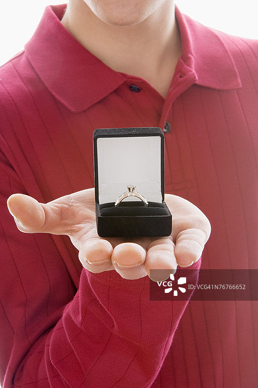 男人手拿装有订婚戒指的盒子图片素材