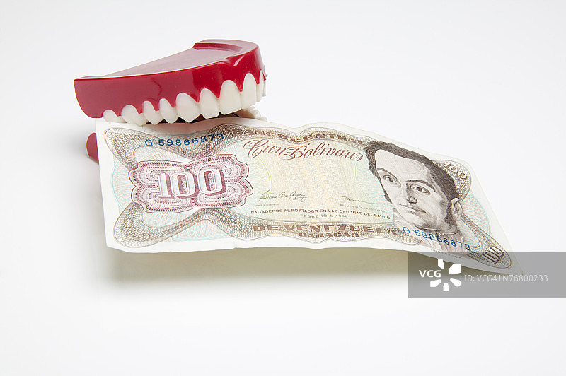 假牙啃咬委内瑞拉货币图片素材