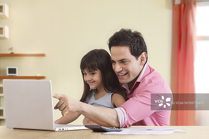 父女在笔记本电脑上看家庭财务图片素材