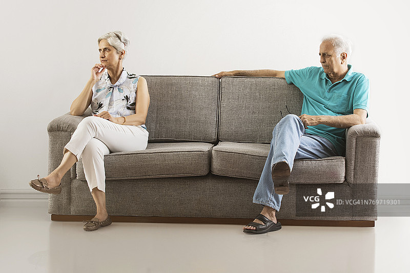 愤怒老年夫妇分开坐沙发图片素材