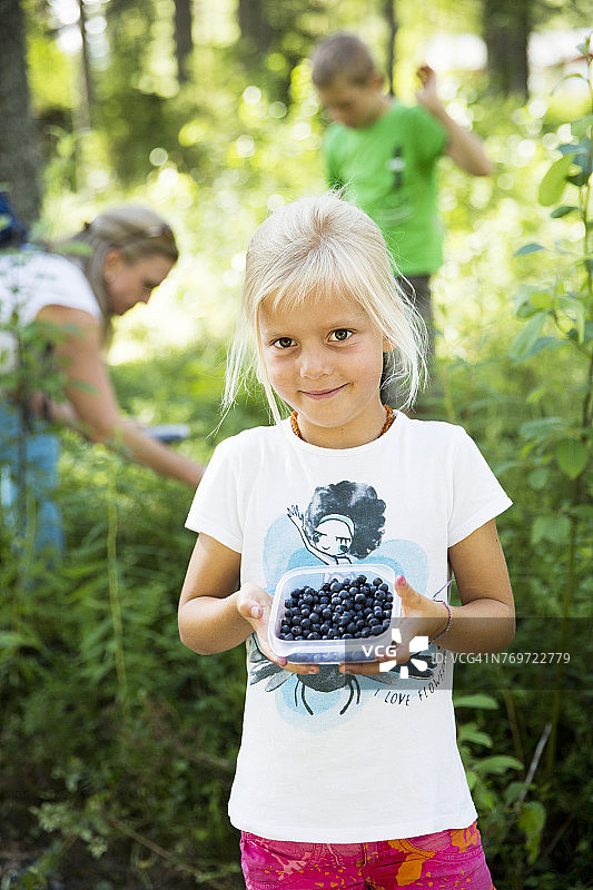 拿着盒子里的蓝莓的女人图片素材