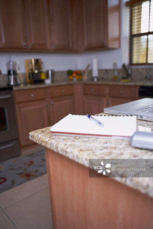 厨房台面上的螺旋笔记本电脑图片素材