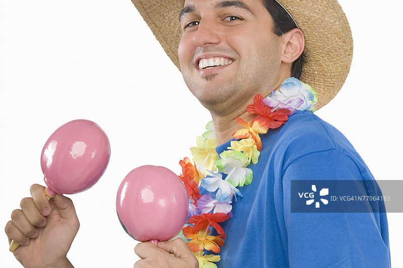 微笑着玩沙锤的年轻男子肖像图片素材