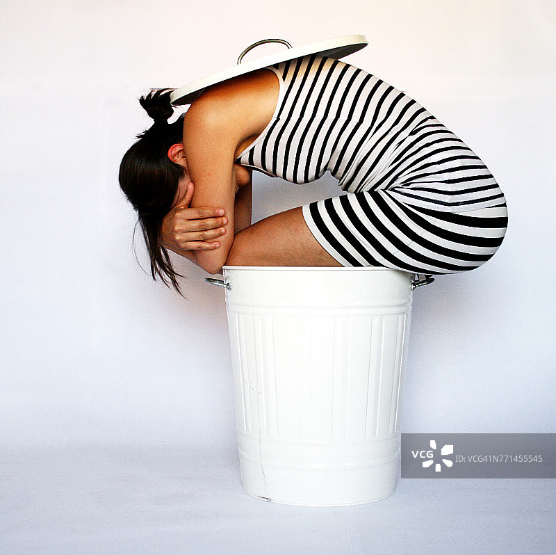 女人坐在垃圾桶里图片素材