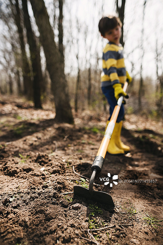 男孩用锄头挖土图片素材