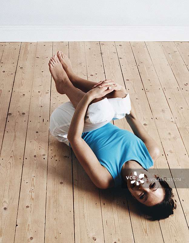 做小船瑜伽姿势的微笑女人图片素材