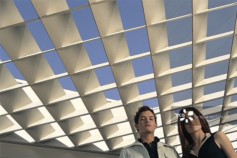 男人和女人站在玻璃中庭下图片素材