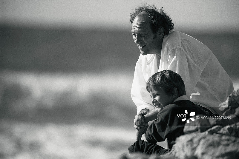 爷爷和孙子在岩石海滩上图片素材