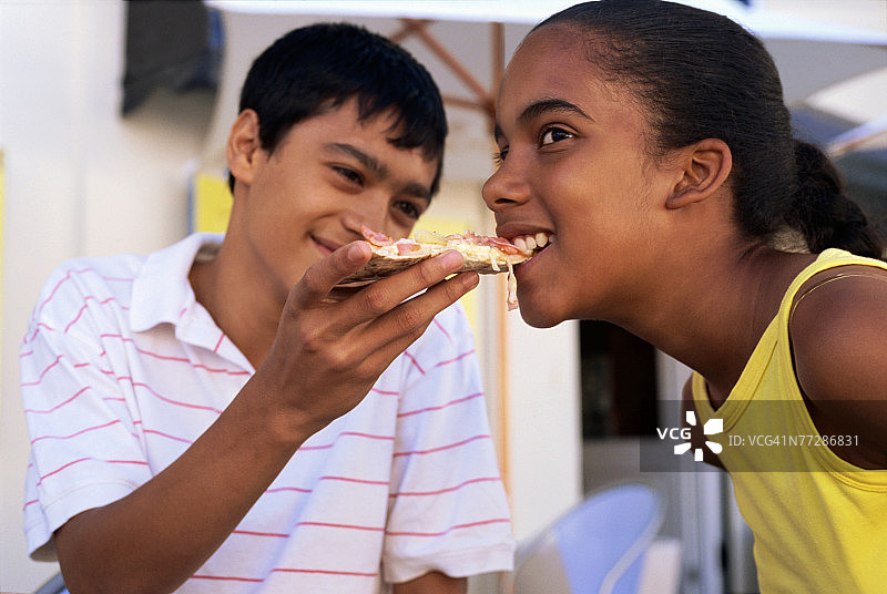 男孩喂女孩一片披萨图片素材