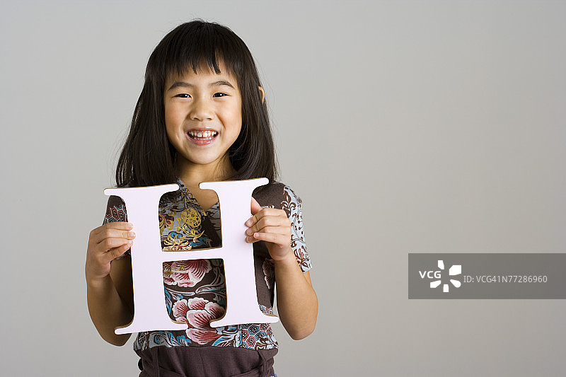 女孩拿着字母H图片素材