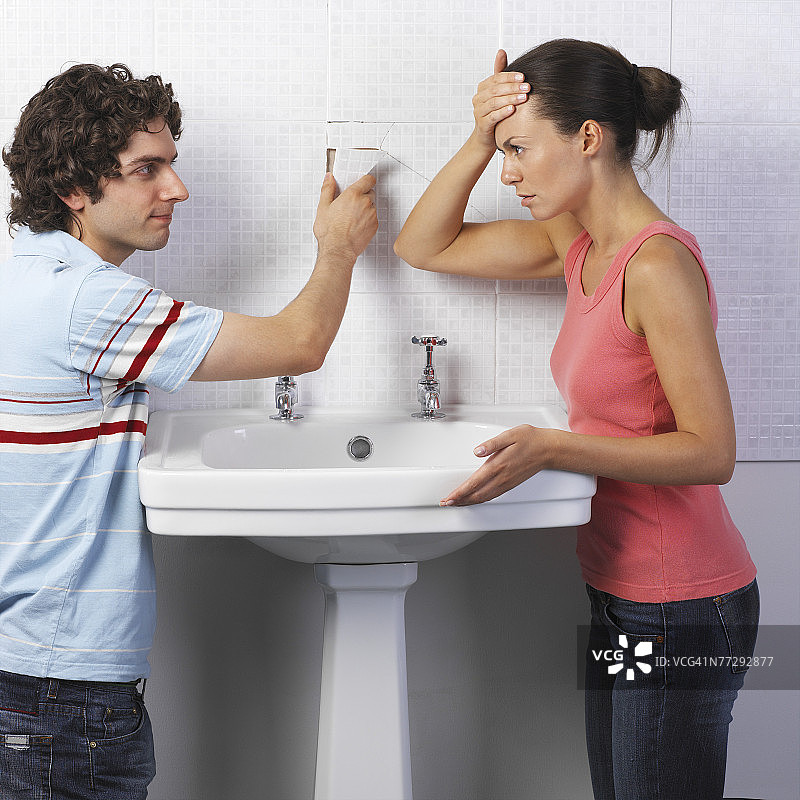 男人和女人因浴室瓷砖破损而沮丧图片素材