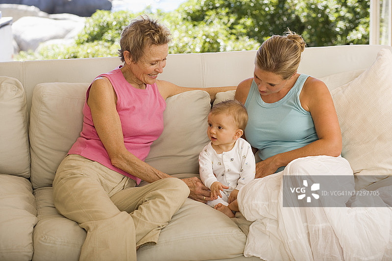 坐在沙发上带宝宝的女人图片素材