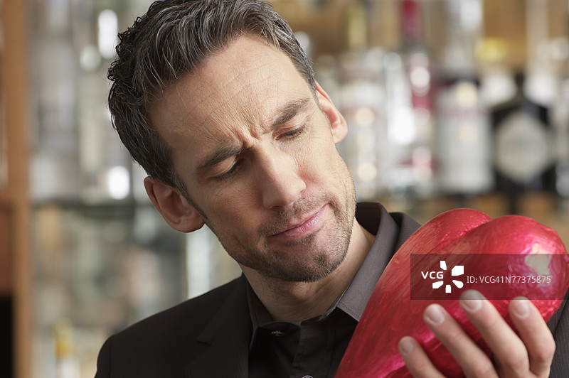 男人手持巧克力心形糖果图片素材