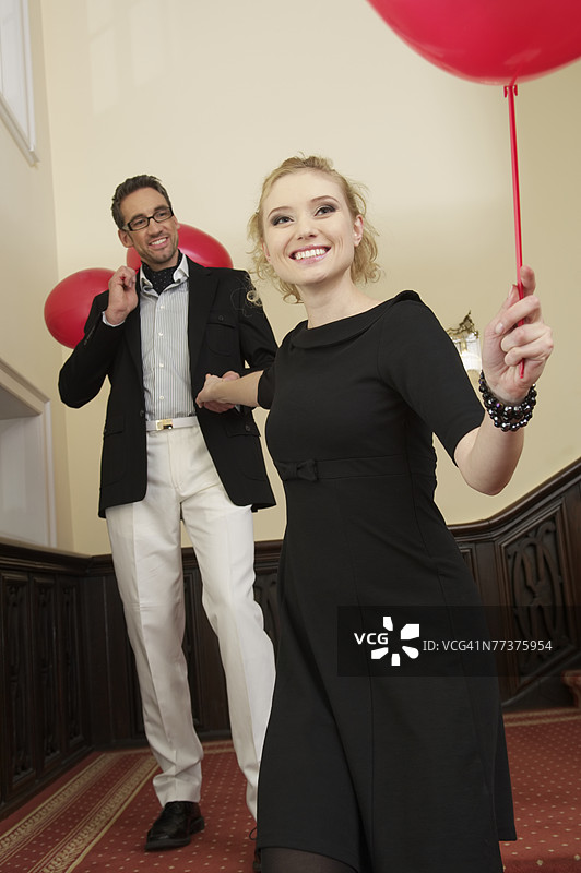 一对情侣在楼梯上拿着气球图片素材