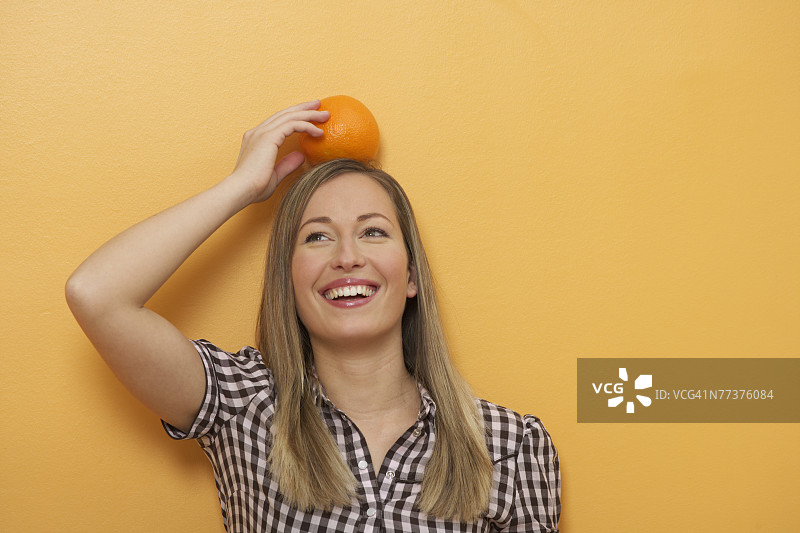 头顶橘子的女人图片素材