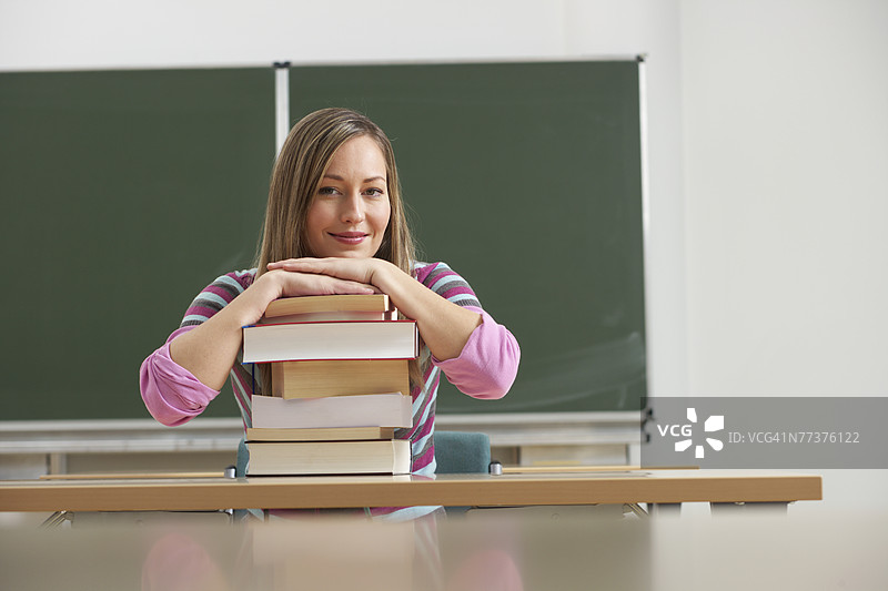 一位女性站在一堆书后面图片素材