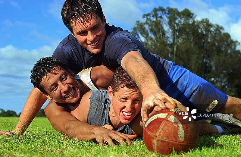 三个青少年男孩踢足球照片图片素材