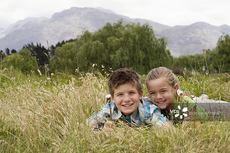 在田野里烤棉花糖的男孩和女孩图片素材