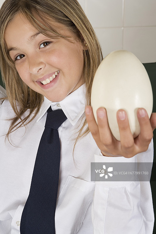 拿着鸵鸟蛋的女学生肖像图片素材