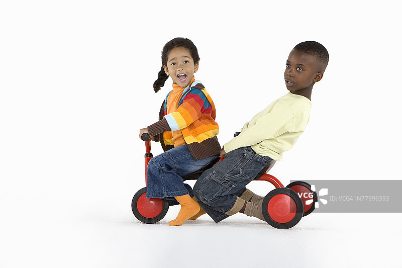 两个小孩一起骑三轮车图片素材