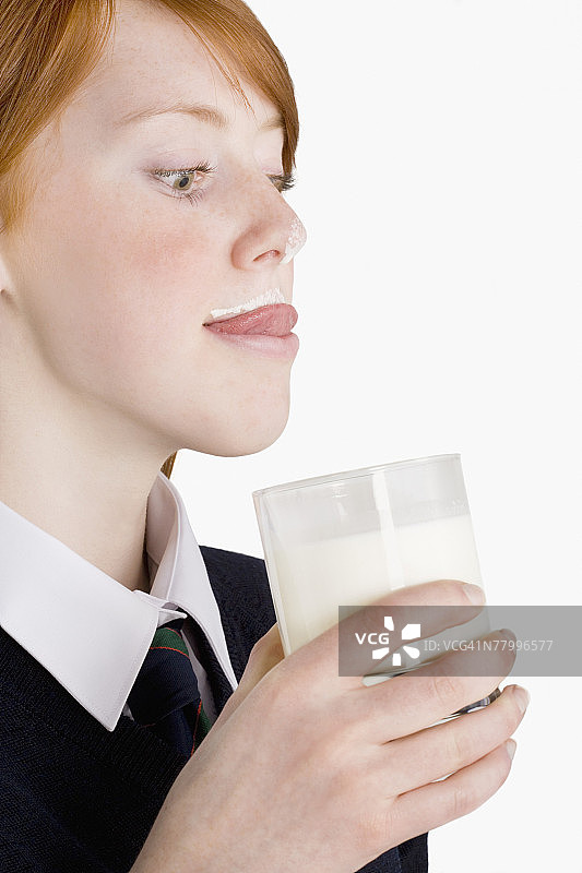 喝一杯牛奶的青少年女孩肖像图片素材