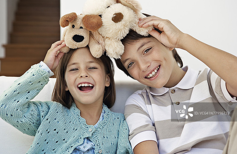 在家玩泰迪熊的姐弟肖像图片素材