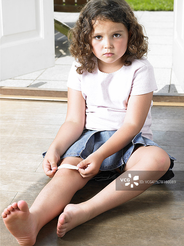 女孩在膝盖上贴创可贴图片素材