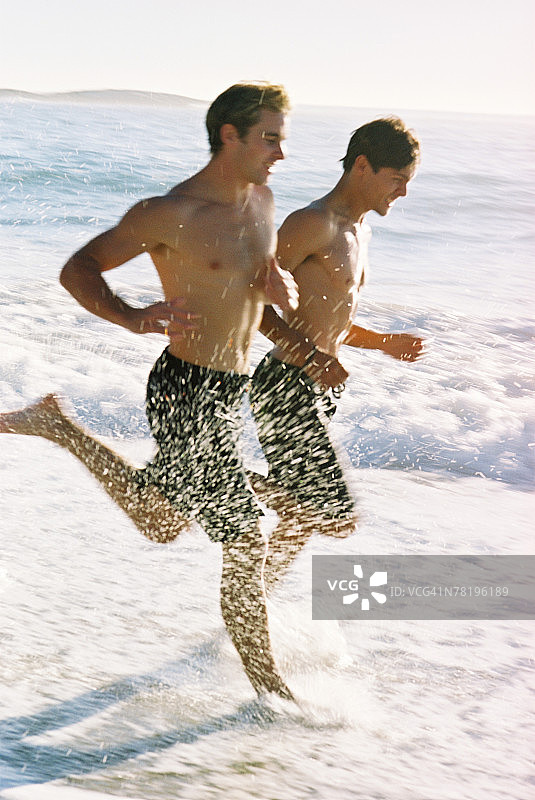 在海滩上奔跑的青少年男孩图片素材