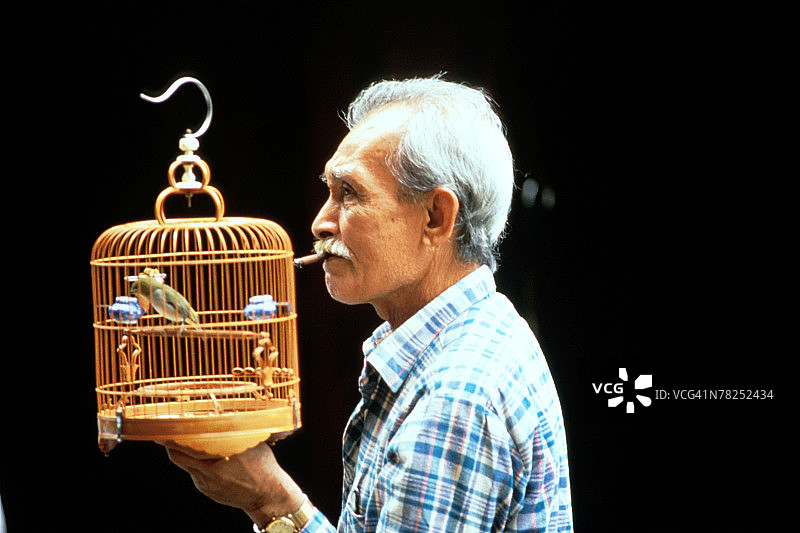 男子提着鸟笼图片素材