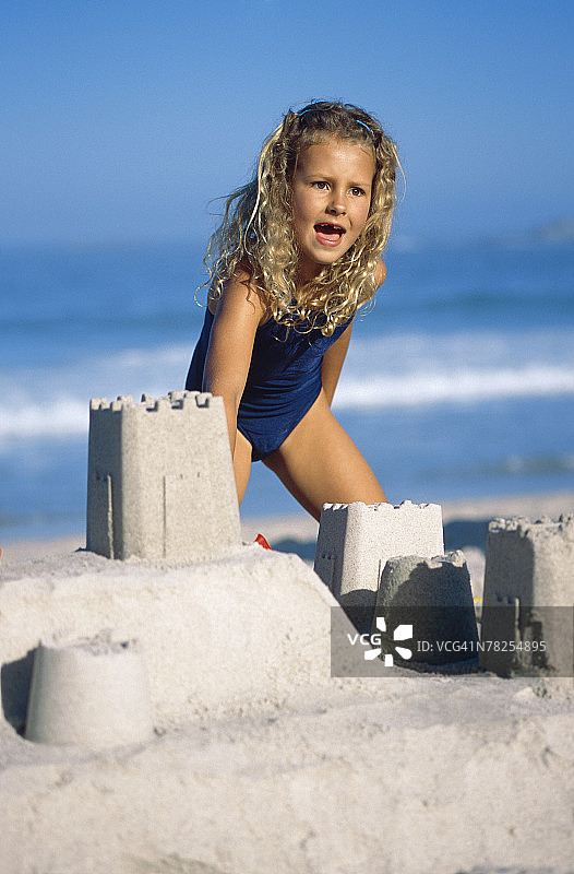 女孩在沙滩上建造沙堡图片素材