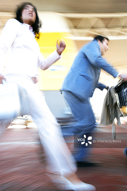 情侣推着行李车赶路图片素材