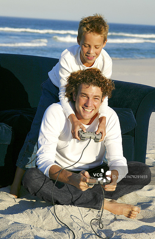 父子在海滩玩电子游戏图片素材