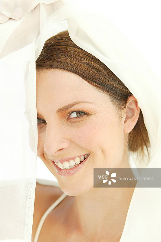 透过雪纺纱窥视的微笑女人图片素材