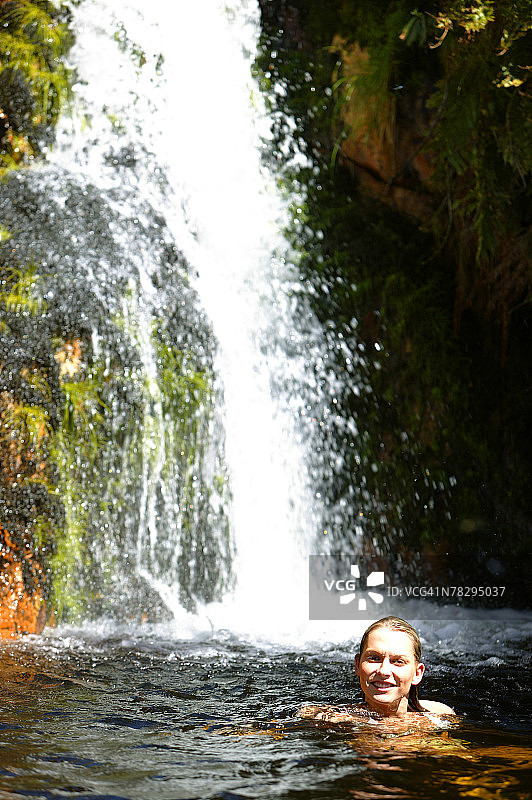 在瀑布旁游泳的女人图片素材