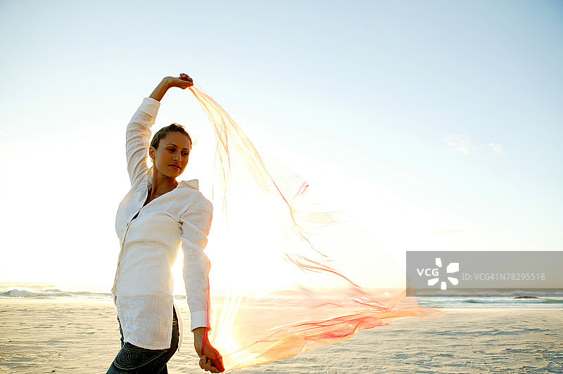 在海滩上戴着面纱跳舞的女人图片素材