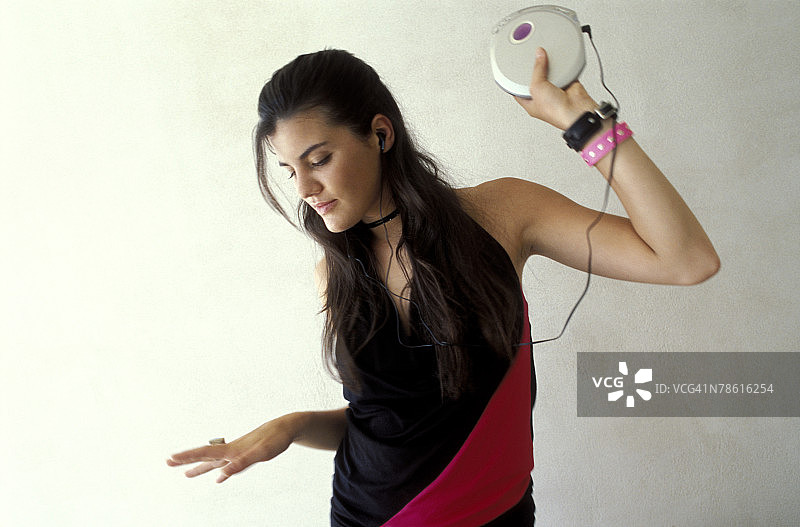 女人听便携式CD播放器跳舞图片素材