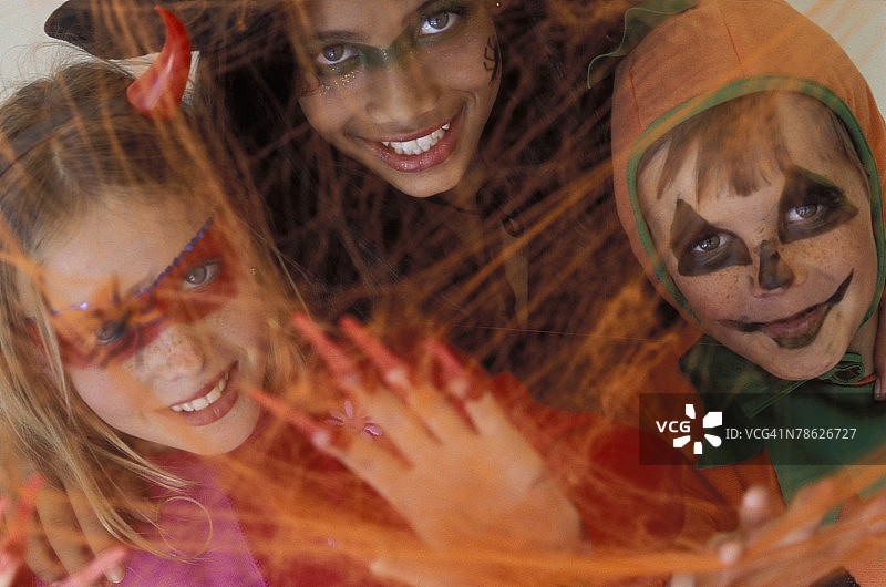 孩子们穿着万圣节服装被困在蜘蛛网中图片素材