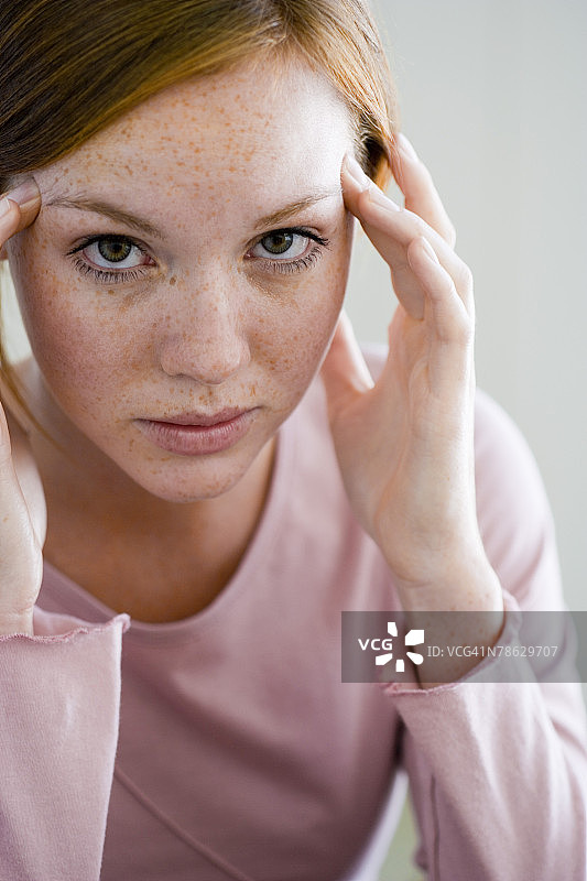 双手按在太阳穴上的女人图片素材