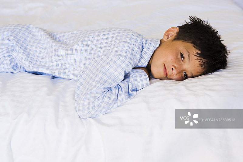 困倦的男孩躺在床上图片素材