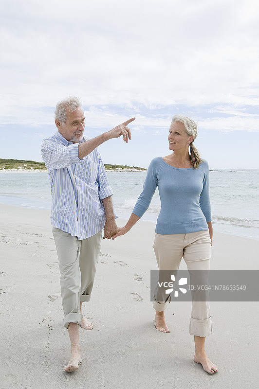 中年夫妇在沙滩上散步图片素材