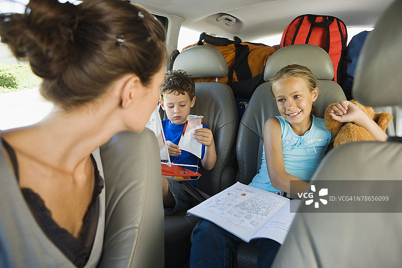 母亲看着汽车后座上的孩子们图片素材