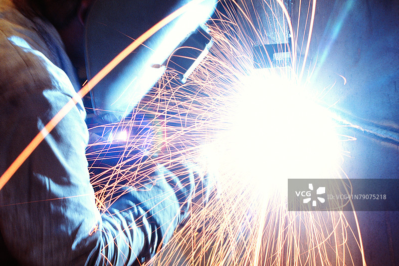 焊工在美国伊利诺伊州芝加哥焊接金属的侧面轮廓图片素材