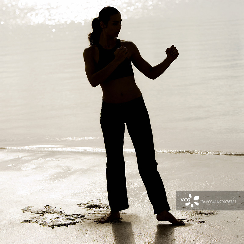 青年女人沙滩练习武术剪影图片素材
