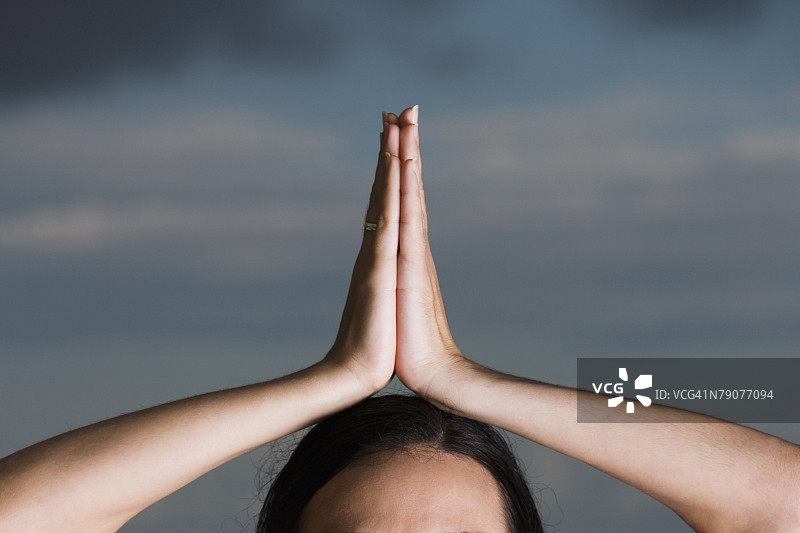 近距离拍摄：祈祷姿势的女人图片素材