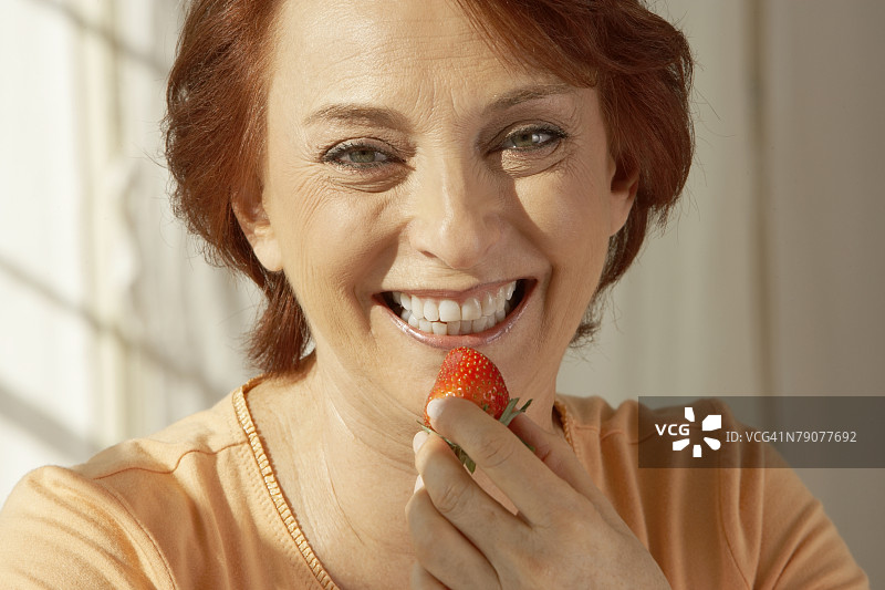 拿着草莓的年长妇女肖像图片素材