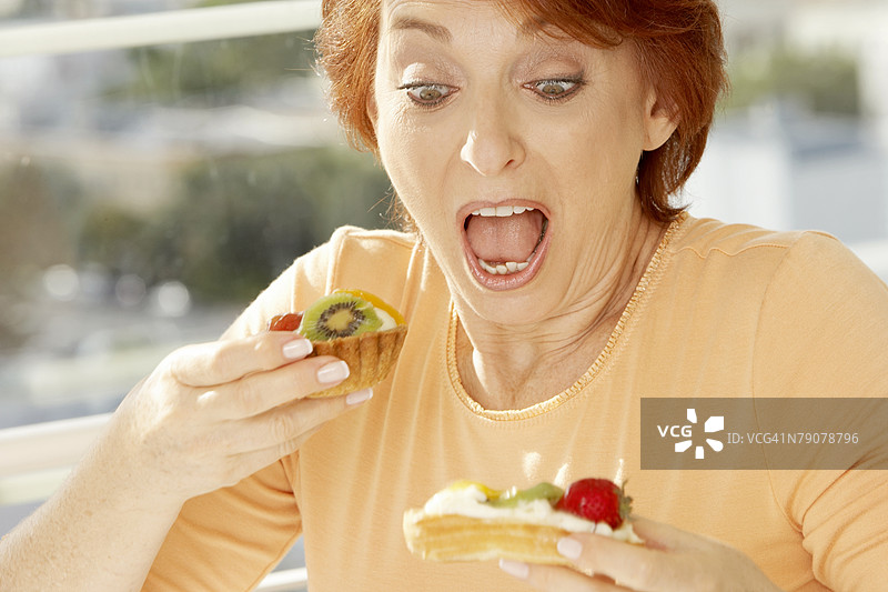 特写镜头：一位老年女性在看水果塔图片素材