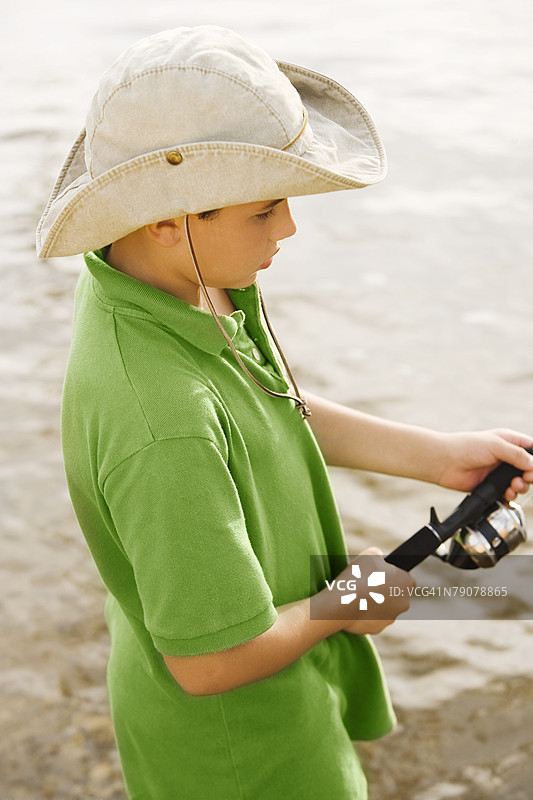 高角度视图的少年在湖中钓鱼图片素材